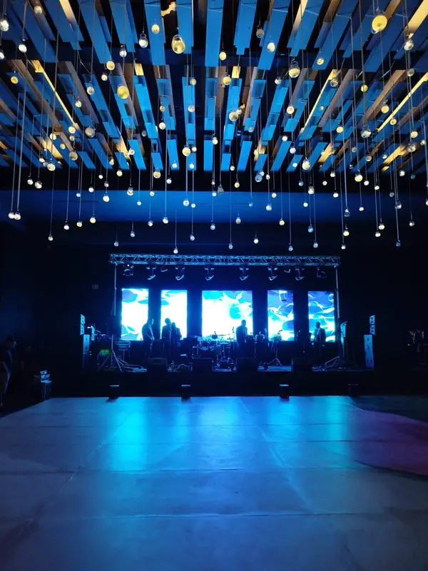 Escenario de un evento social con cinco pantallas LED detrás de la banda