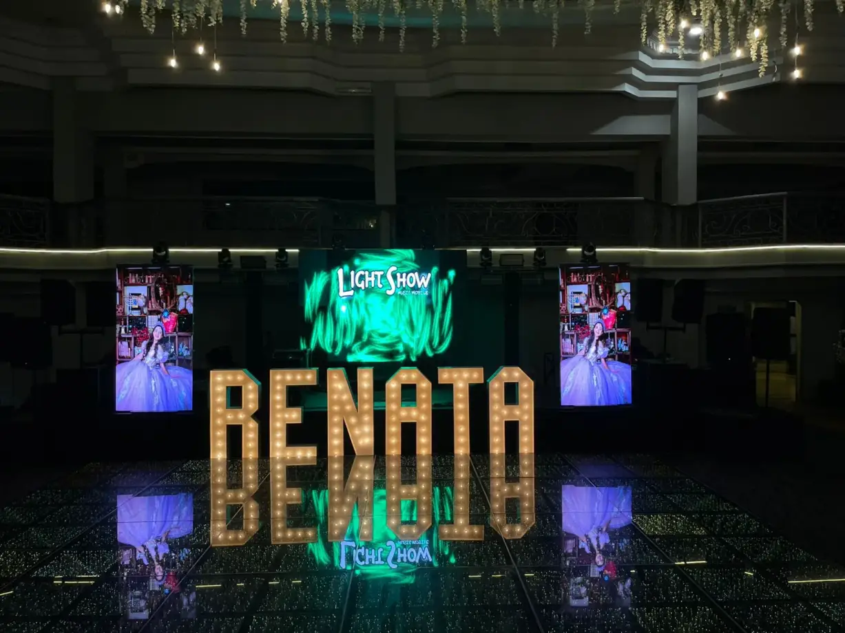 Light show con letras iluminadas y pantallas LED en un salón